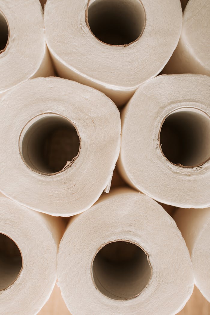 Close-up view of stacked toilet paper rolls, highlighting hygiene and essential supplies.